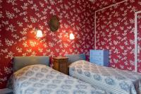 two beds in a room with red wallpaper at Hotel Esmeralda in Paris