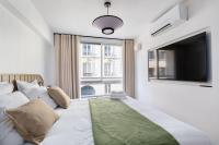 a bedroom with a bed with a flat screen tv at La Perle de Kléber in Paris