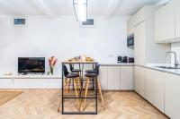 a kitchen with white cabinets and a counter with stools at Appartement moderne proche Montmartre in Paris