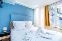 a bedroom with a bed with white towels on it at Appartement moderne proche Montmartre in Paris