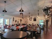 un grupo de personas sentadas en mesas en un restaurante en Village 17 gites, Piscine, Restaurant , 2 gites avec SPA, 3km de Conques, en Conques