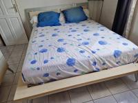 a bed with blue pillows on top of it at La maison du Pêcheur in Terre-de-Haut
