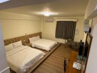 a hotel room with two beds and a television at Yawan Hotel in Wenquan