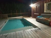 a swimming pool on a deck with a couch and a bed at comme chez vous in Taussat-les-Bains