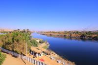 a view of a river with a train on it at Nubian Popeye - Roof top - Nile View in Aswan