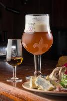 a glass of beer and a plate of food on a table at The Anderson in Fortrose