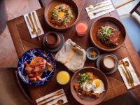 Una mesa de madera con platos de comida encima. en Casona Alonso 10- Hotel Boutique, en Guanajuato