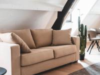 a brown couch in a living room with a cactus at Modern holiday home in Bazel with garden in Bazel
