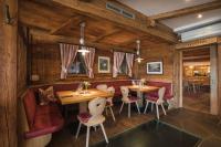 a restaurant with wooden walls and tables and chairs at Apartments Pitschlmann in Fiè