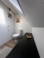 a bathroom with a toilet and a black table at Calme, Confort et Propreté in Vittel
