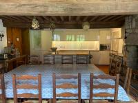 a kitchen with a table and chairs and a kitchen with white appliances at Ancienne Auberge des Brizards - Morvan (14 personnes) in Quarré-les-Tombes