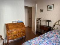 a bedroom with a dresser and a bed and a table at Appartement T3 bord de la Vienne in Chinon