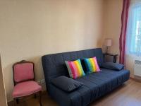 a blue couch with colorful pillows in a living room at Appartement T3 bord de la Vienne in Chinon