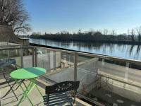 a balcony with a table and chairs and a view of a river at Appartement T3 bord de la Vienne in Chinon