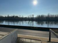 a road next to a river with the sun in the sky at Appartement T3 bord de la Vienne in Chinon