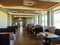 ein Restaurant mit Leuten, die an Tischen in einem Zimmer sitzen in der Unterkunft Mountain Sky View - Маунтин Скай Вю in Gabrowo