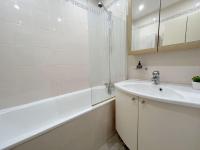 a white bathroom with a sink and a bath tub at Appartement met 2 slaapkamers-VAYA G002 in De Panne