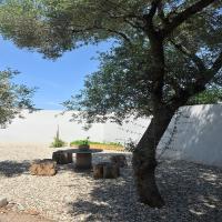 a park with a tree and a table and logs at Appartement Le Lido de la Marana in Lucciana