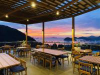 un restaurante con mesas y sillas y una puesta de sol en Zasgo Hotel, en Labuan Bajo