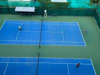 two people playing tennis on a tennis court at Sivalai Place in Bangkok