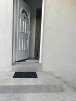 a white door in a white building with a rug at Appartement Le Lido de la Marana in Lucciana