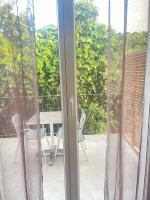 a sliding glass door to a patio with a table and chairs at Appartement Le Lido de la Marana in Lucciana