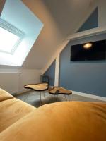 a bedroom with two tables and a skylight at Hôtel du Musée in Granville