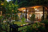 宁平Hoang Minh Mountainside Villa的夜晚花园里一栋房子，里面有一条长椅。