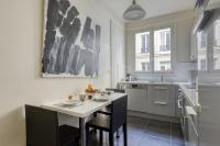 a kitchen with a white table and chairs in a room at Gorgeous and large flat in the heart of Paris 09 in Paris