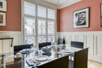 a dining room with a table and chairs and a window at Gorgeous and large flat in the heart of Paris 09 in Paris