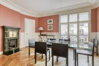 a dining room with a table and chairs and a fireplace at Gorgeous and large flat in the heart of Paris 09 in Paris