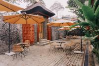 un patio esterno con tavoli, sedie e ombrelloni di Camaradvipa Retreat Munduk a Munduk