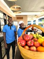 a man and a woman standing next to a basket of fruit at Kololi Sands Apartments in Kololi