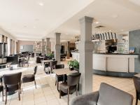 Un restaurante con mesas y sillas y un bar. en Domein Westhoek, en Oostduinkerke