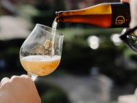 una persona está vertiendo una copa de vino en Domein Westhoek, en Oostduinkerke