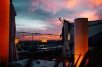 Blick auf eine Terrasse mit Tischen und Sonnenschirmen bei Sonnenuntergang in der Unterkunft Sea Paradise Studio in Mamaia Nord – Năvodari