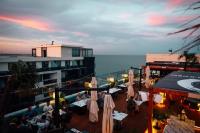 eine Gruppe von Personen, die auf einem Balkon an Tischen sitzen in der Unterkunft Sea Paradise Studio in Mamaia Nord – Năvodari