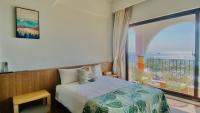 a bedroom with a bed and a large window at Mini Summer in Nanwan