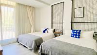 a hotel room with two beds and a window at Mini Summer in Nanwan