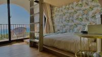 a bedroom with a bed and a balcony with a laptop at Mini Summer in Nanwan