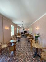 a room with tables and chairs and a couch at HOTEL LE FLOREAL in Le Soler