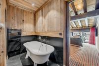 a bathroom with a tub and a sink at HOTEL LE VAL D&#39;ISERE in Val-d&#39;Isère