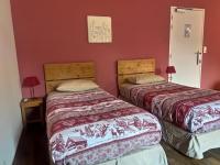 two beds in a room with red walls at Les Chemins du Léman in Novel