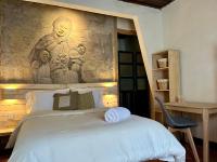 Un dormitorio con una cama con un cuadro en la pared. en Casa Cheleb, en San Cristóbal de Las Casas