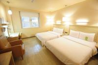 a hotel room with two beds and a chair at Kindness Hotel - Jhong Jheng in Kaohsiung