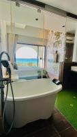 a bath tub in a room with a bed at Mini Summer in Nanwan