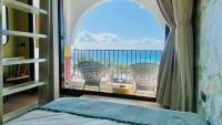 a bedroom with a window with a view of the ocean at Mini Summer in Nanwan