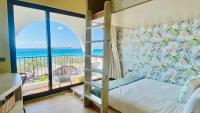 a bedroom with a bunk bed and a balcony with the ocean at Mini Summer in Nanwan