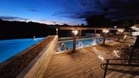 a swimming pool at night with people in the water at Resort QSB - Um novo padrão de conforto e lazer no coração da cidade in Pirenópolis