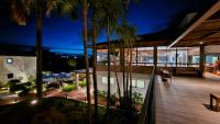 a view of a building with palm trees at night at Resort QSB - Um novo padrão de conforto e lazer no coração da cidade in Pirenópolis